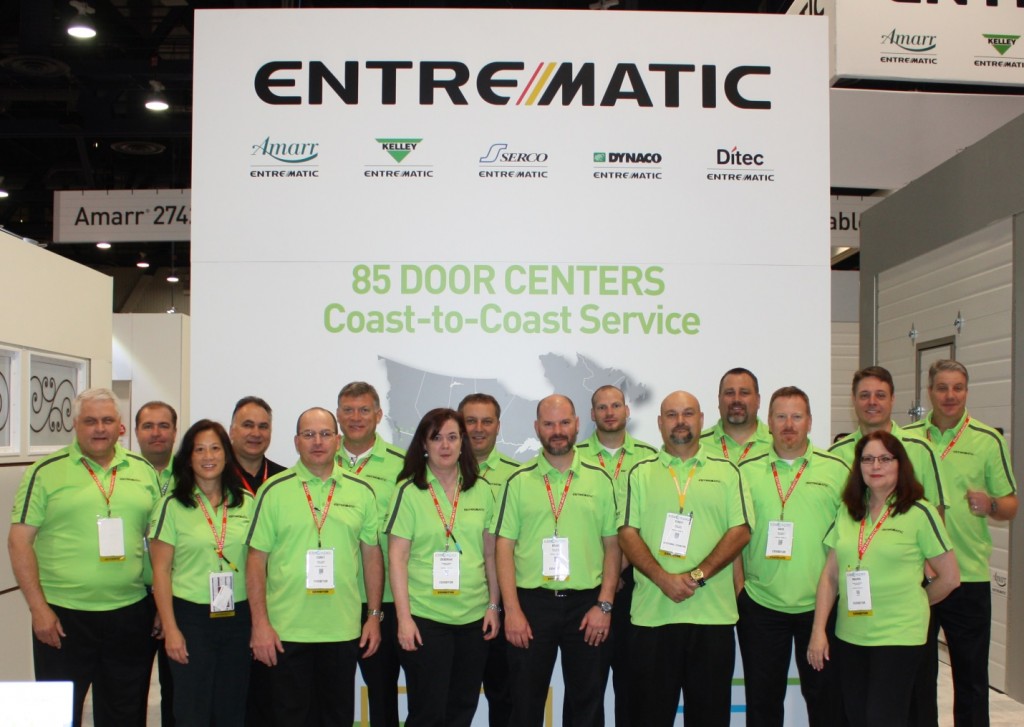 Entrematic Team Members stand by the part of the booth dedicated to our 85 Door Center celebration.