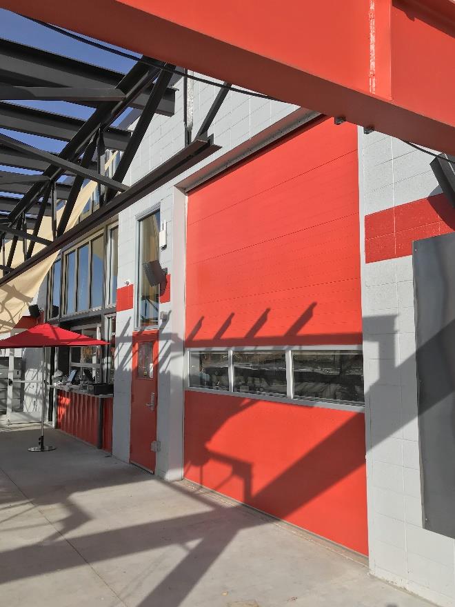 Glass sectional doors opening to outdoor seating area in retail space