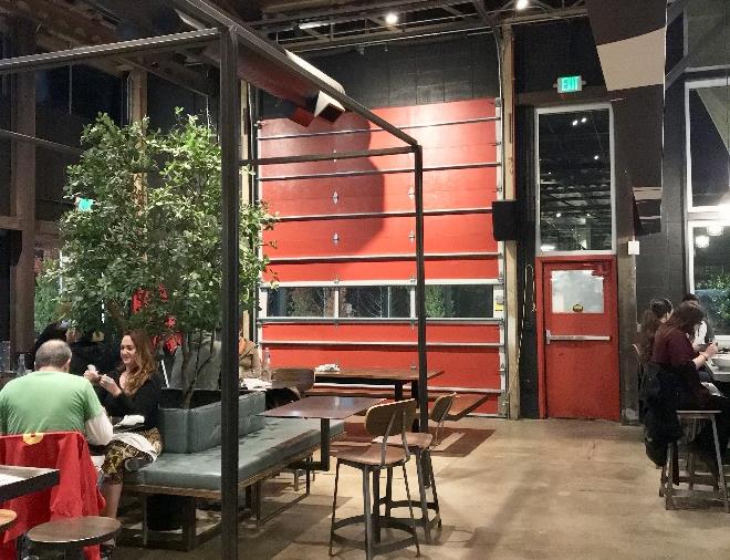 Restaurant seating area with open glass doors connecting to exterior