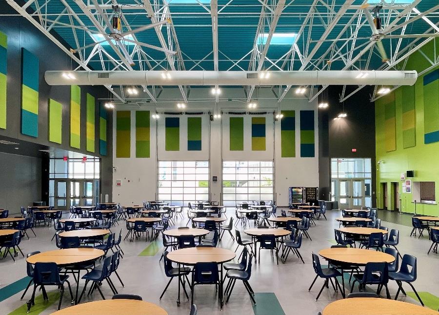 Modern school dining area with full-view aluminum sectional doors and high ceilings