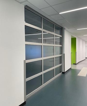 School hallway with aluminum full-view glass sectional door connecting spaces