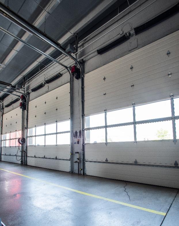 Interior fire station bay with glass panel sectional doors and high ceiling