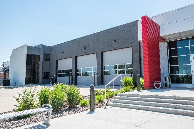Modernized fire station exterior with multiple overhead doors and landscaping