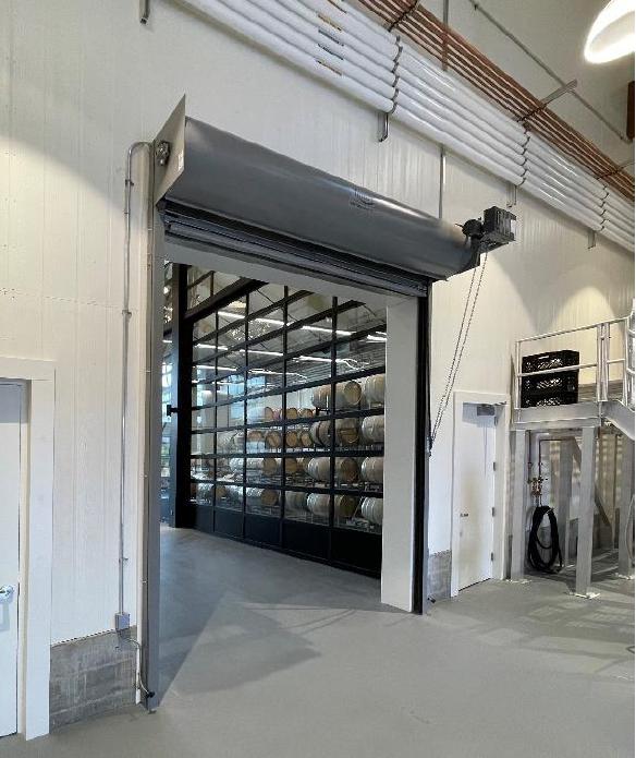 Wine barrels visible through insulated glass doors