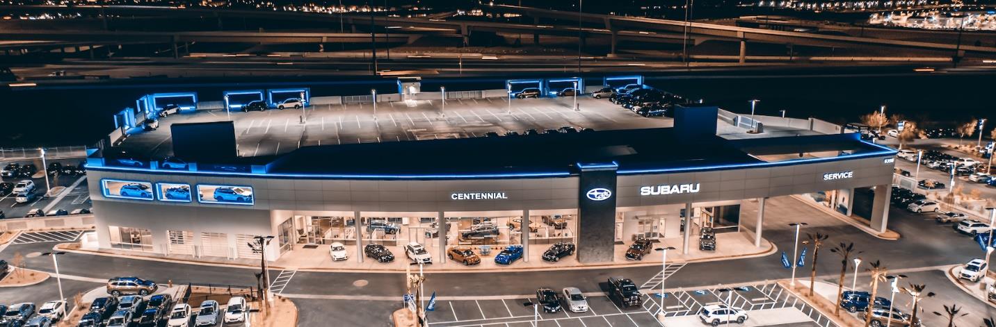 Large modern Subaru dealership building illuminated at night