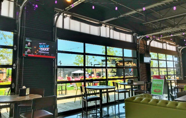 Restaurant and bar area with full-view aluminum doors opening to outdoor space