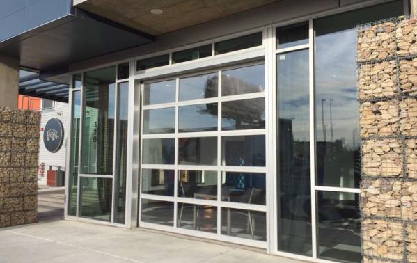 Apartment exterior glass wall with full-view sectional doors and stone facade