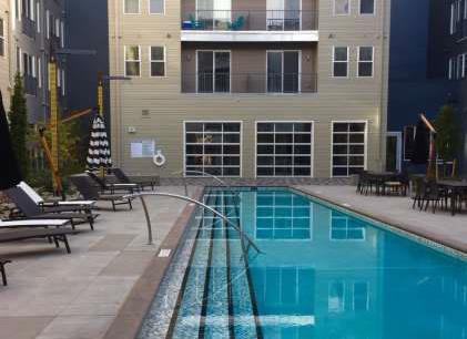 Outdoor lap pool courtyard at apartment complex with lounge chairs