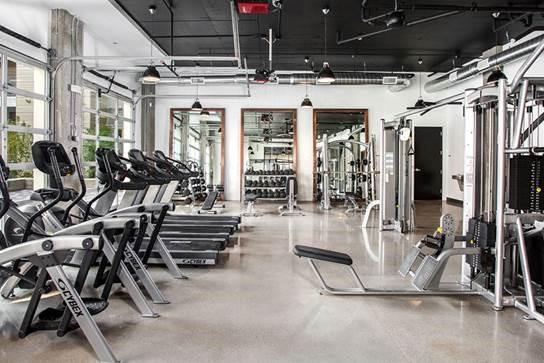 Apartment fitness center with treadmills and full-view glass sectional doors