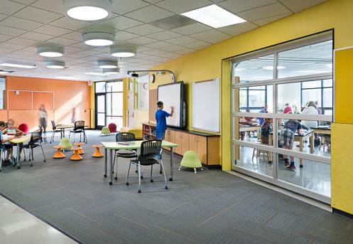 Elysian K-8 classroom with collaborative layout and glass door partition