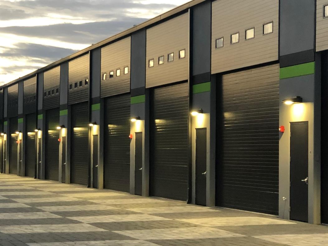 Luxury garage condominium units with black steel sectional doors at sunset