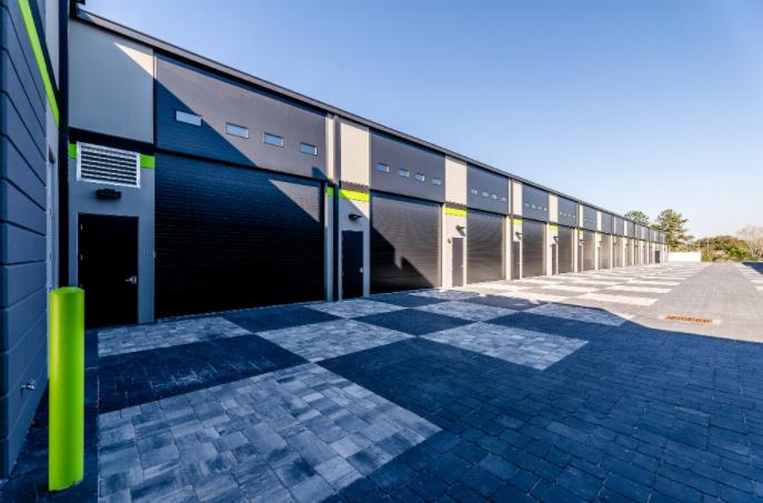 Garage condo complex with black doors and green accent stripe columns