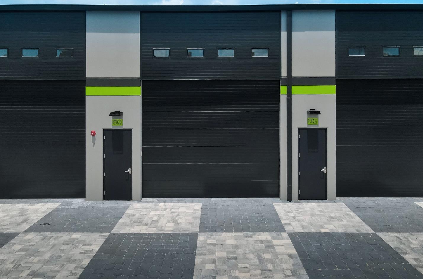 Close-up of modern black steel garage doors with small window panels