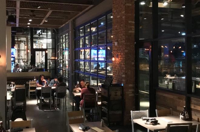 Brewery interior with large glass sectional doors and dining tables