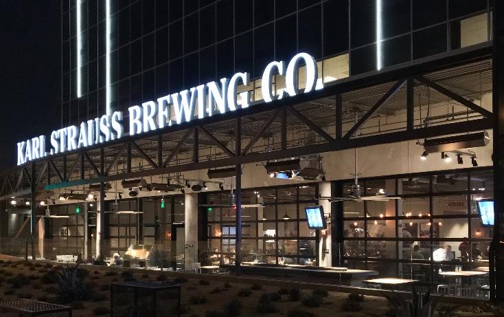 Brewpub exterior at night with signage and indoor-outdoor seating