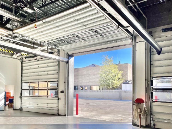 Interior fire station vehicle bay with insulated steel sectional doors
