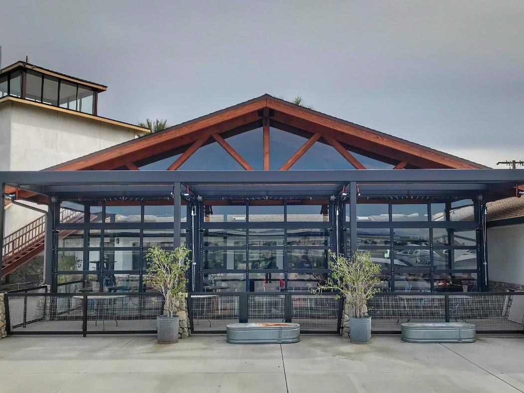 Maniac-Mike’s Café exterior with aluminum glass doors and open seating area