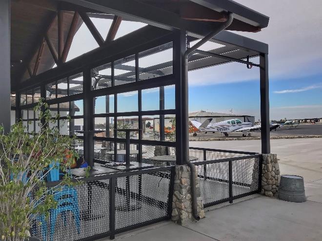 Patio seating area with glass doors overlooking airport runway