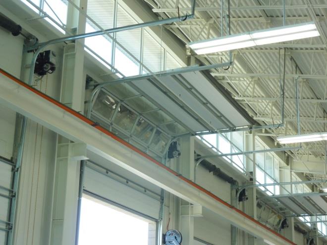High-lift sectional doors inside large vehicle maintenance facility