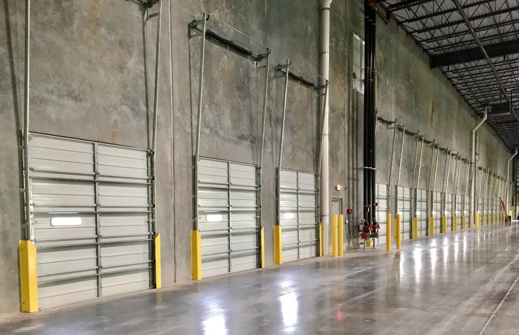 Large warehouse interior with multiple steel sectional loading dock doors