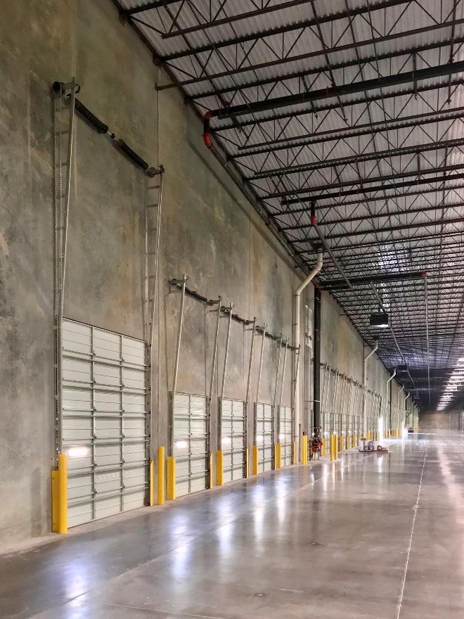 Long row of warehouse dock doors with vertical lift track system