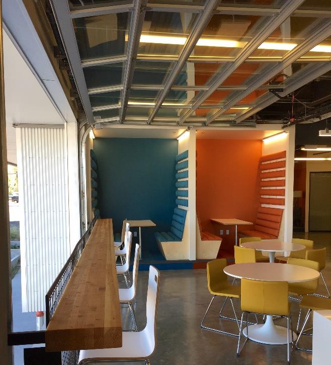 Office bar-style seating area with open glass door and mountain views