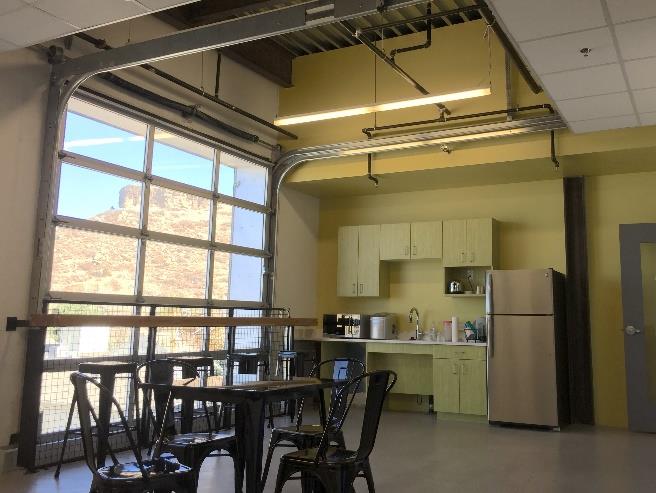 Glass sectional door opening in office space with scenic outdoor view