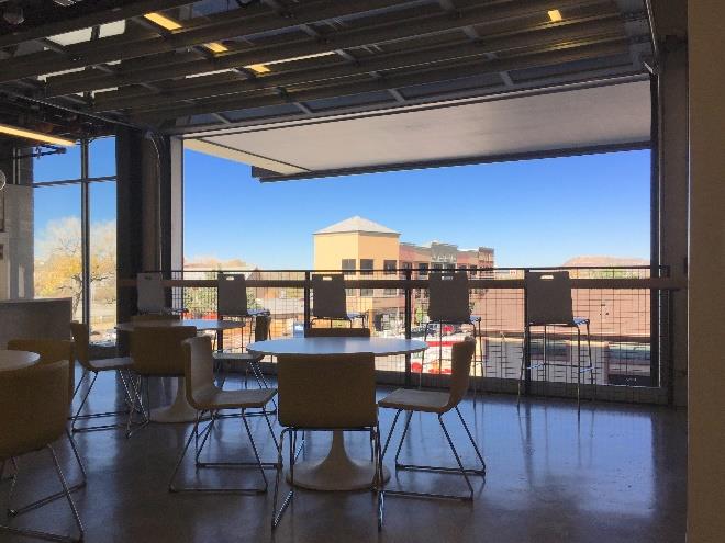 Modern office lounge with sectional glass doors and open ceiling design