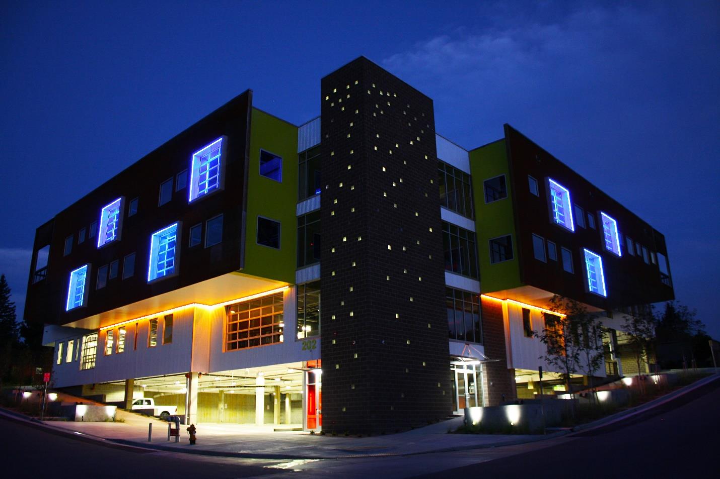 Office building illuminated at night with LED-lit glass door openings