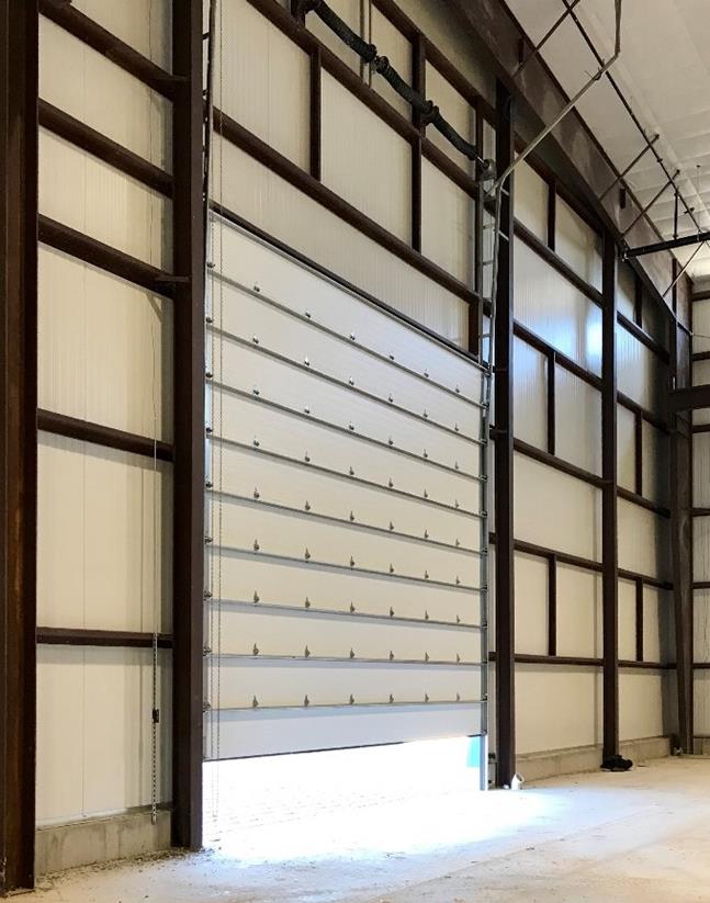 Tall steel sectional door installed in high-ceiling industrial building