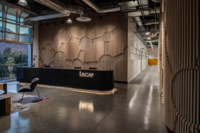 Interior reception lobby with full-view glass doors opening to outdoor patio