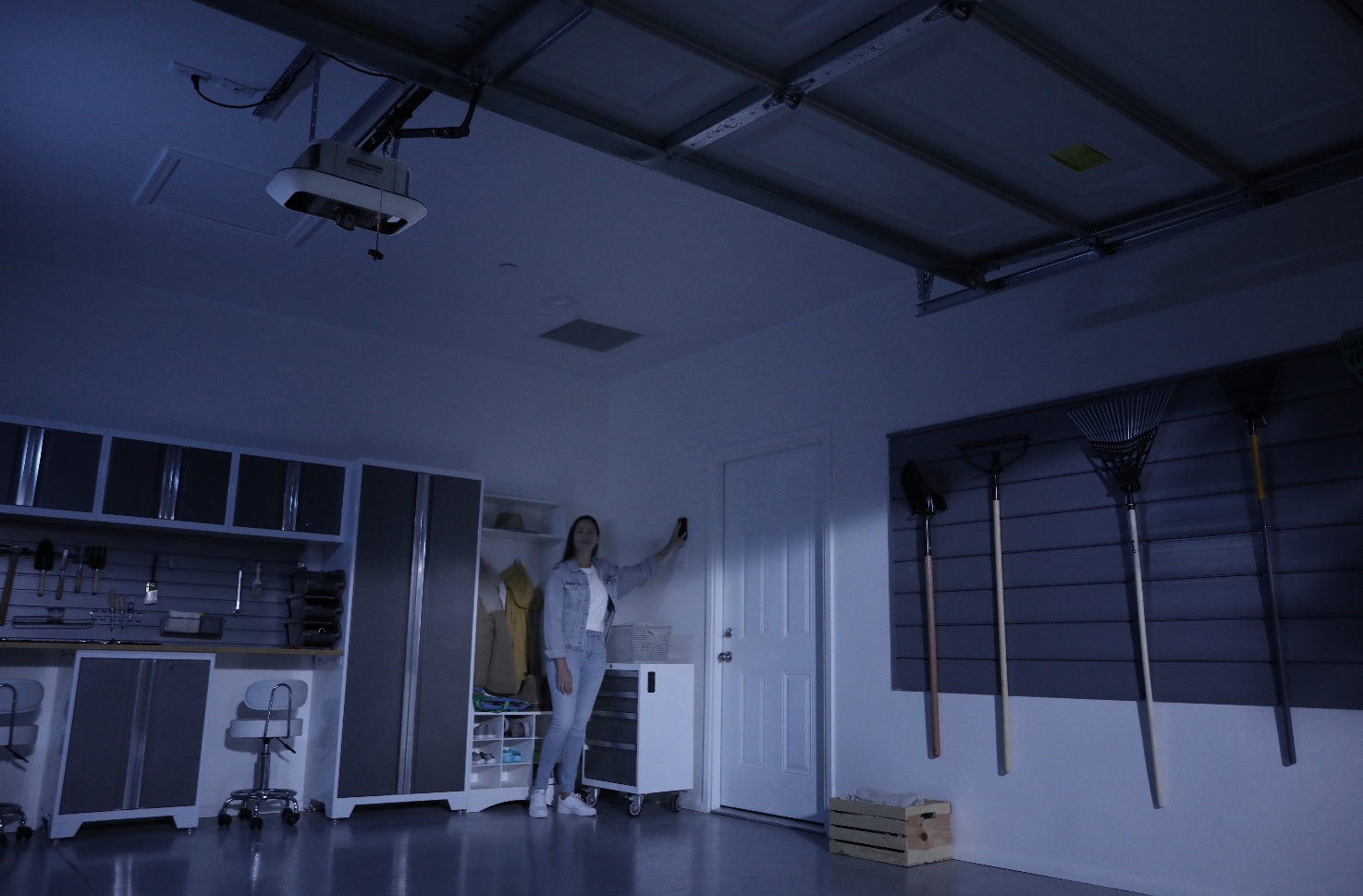 Battery backup module closeup + lifestyle of homeowner operating garage during storm