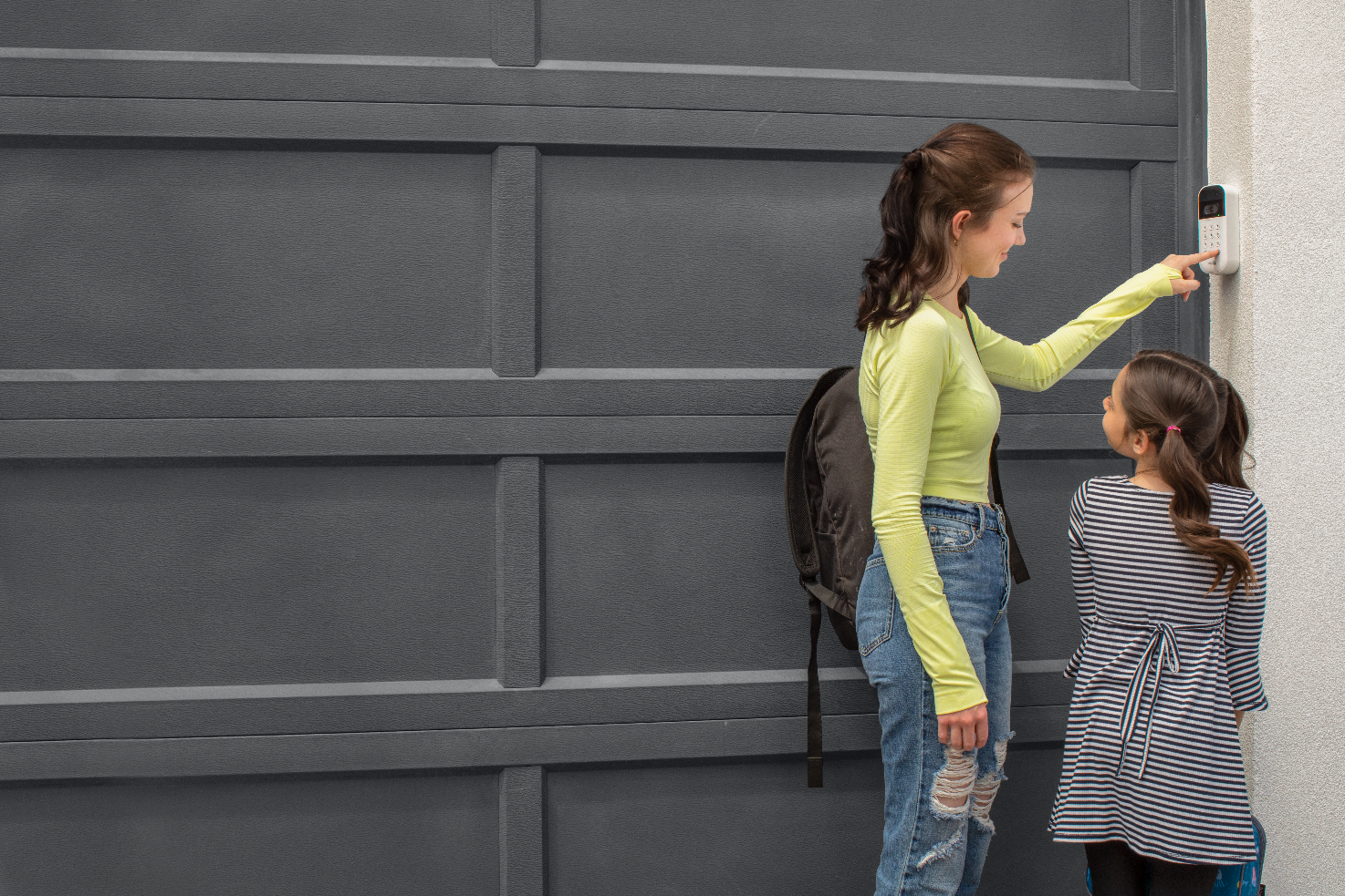 Video keypad + outdoor camera lifestyle  parent checking phone as kid arrives home
